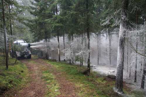 Unimog der im Wald fährt und Kalk verteilt