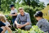 Landesrat Stefan Kaineder im Gespräch mit Kindern in einem Garten