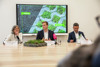 Sibylla Zech, Landesrat Stefan Kaineder und Johann Urwanisch sitzen nebeneinander an einem Konferenztisch, im Hintergrund Videowand mit dem Bild eines versiegelten bzw. nicht versiegelten Bodens und Beschriftung Vorher/Nachher
