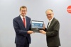 Landesrat Markus Achleitner und DI Dr. Gerhard Dell stehen nebeneinander und halten gemeinsam einen Laptop, auf dem am Bildschirm Öko-Check-Portal für Unternehmen, Energie- und Treibhausgasbilanz für Ihr Unternehmen zu sehen ist
