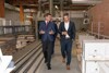 Landesrat Markus Achleitner und Christian Schäfer gehen nebeneinander im Gespräch durch eine Betriebshalle