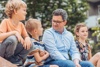 Landesrat Mag. Michael Lindner sitzend im Gespräch mit drei Kindern