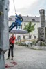 Kletterwand im Linzer Landhauspark, ein Kind beim Klettern wird von einem Mann gesichert