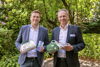 Umwelt- und Klima-Landesrat Stefan Kaineder und Bgm. Roland Wohlmuth halten Mehrwegbecher und Kuchenboxen in Händen