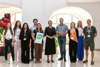 Gruppenfoto in einem Raum mit großen Bogenfenstern, Thomas Zwirzitz, Beate Dunzinger, Tina Blöchl und Landesrat Stefan Kaineder mit sechs jungen Menschen 