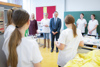 Sozial-Landesrat Wolfgang Hattmannsdorfer steht in einem Klassenzimmer, im Austausch mit Lehrpersonen und Pflegekräften.