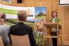 Landesrätin Michaela Langer-Weninger steht an einem Rednerpult vor Publikum, im Hintergrund Fotowand mit Motiven aus der Landwirtschaft