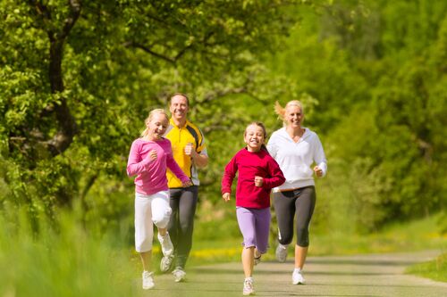 Vierköpfige Familie beim Laufen in einem Wald