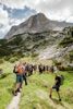 Landesrat Stefan Kaineder und Klaus Reingruber mit einer Gruppe Jugendlicher auf einem schmalen Pfad in gebirgiger Landschaft