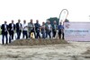 Zehn Personen stehen vor einem Sandhaufen mit je einem Spaten in der Hand. Auf der rechten Seite steht zusätzlich noch ein Plakat „mobil ans Ziel“ mit Bauinformationen.