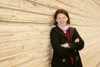 Landesrätin Michaela Langer-Weninger stehend angelehnt an eine Wand aus Holz