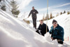 Stefan Reinbacher, Landesrat Stefan Kaineder und Florian Stifter mit Suchstange an einem schneebedeckten Hang in bergiger tiefverschneiter Landschaft