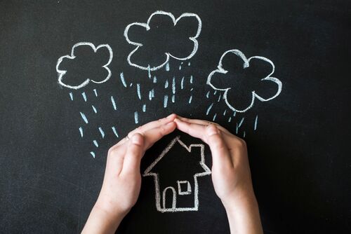Schützend halten sich Hände über die Illustration eines Hauses, über dem es aus Wolken herausregnet