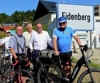 Bürgermeister Adolf Hinterhölzl, Christian Wohlgemuth, Bundesrat Günter Pröller und Mobilitäts-Landesrat Günther Steinkellner stehen mit Fahrrädern vor einer Ortstafel der Gemeinde Eidenberg.  