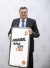 Landesrat Mag. Günther Steinkellner hält ein Schild in Form eines Mobiltelefons, Beschriftung Mobil ans Ziel
