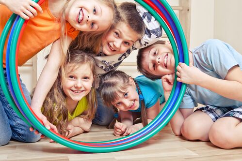 Fünf Kinder schauen durch Hula Hoop-Reifen