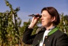 Agra-Landesrätin und Genussland OÖ-Obfrau Michaela Langer-Weninger blickt in einem Weingarten durch ein Refraktometer.
