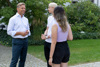 Landesrat Dr. Wolfgang Hattmannsdorfer stehend im Gespräch mit zwei Jugendlichen in einem parkartigen Gelände