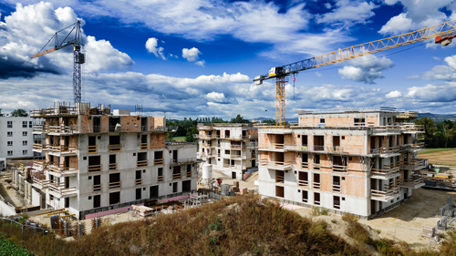 Eine im Bau befindliche Stadtlandschaft, geprägt von modernen Wohnbauprojekten und zahlreichen Baustellen und Kränen.