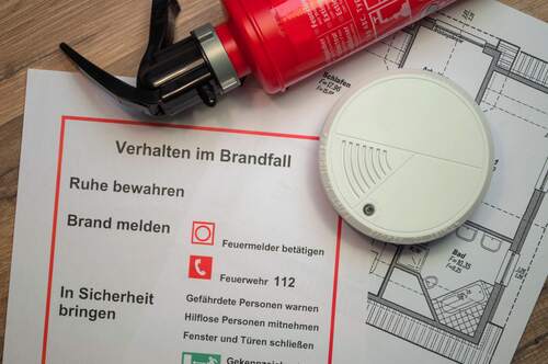 Feuerlöscher, Rauchmelder, Zettel mit Hinweisen zum Verhalten im Brandfall